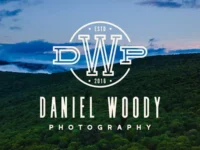 Brand logo for Daniel Woody Photography over a forested hillside landscape